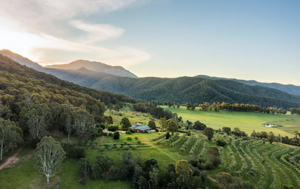 A large valley with the sun and a single house.